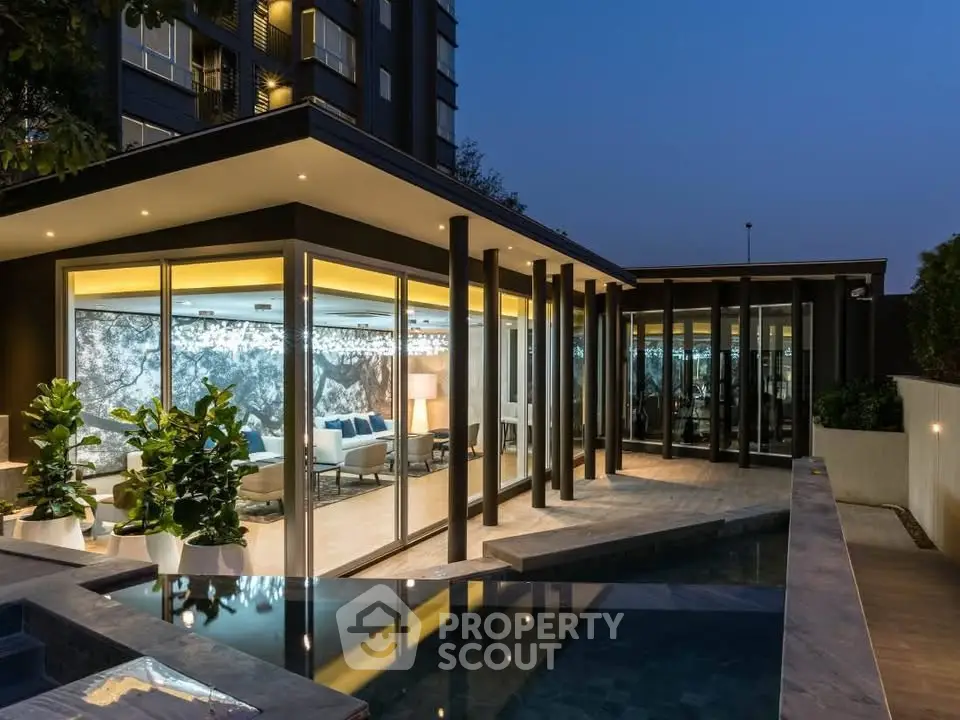Luxurious modern home with floor-to-ceiling windows and pool at dusk, showcasing elegant architecture.