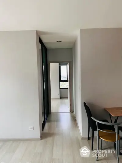 Modern apartment hallway with wooden flooring and dining area