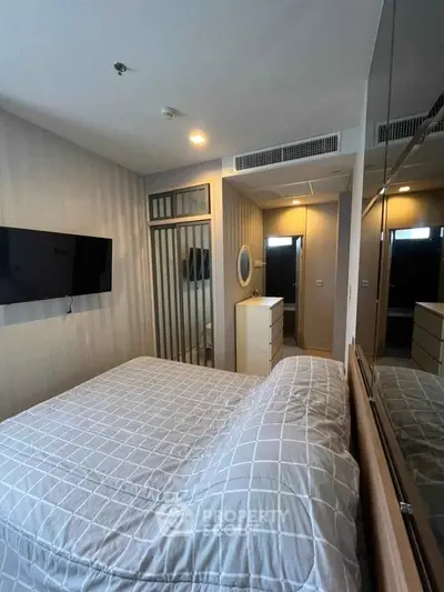 Modern bedroom with stylish decor and wall-mounted TV in a cozy apartment.