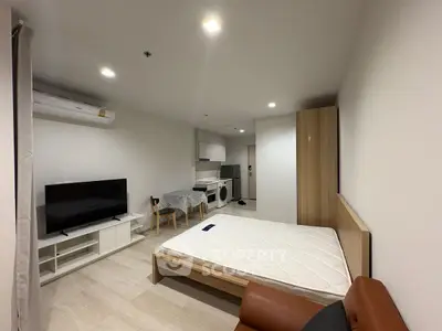 Modern studio apartment with open layout, featuring a cozy living area, kitchen, and bedroom space.