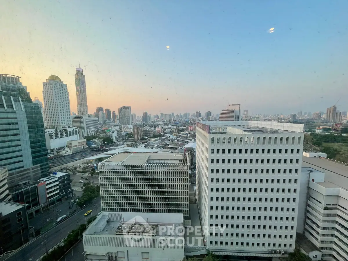 Stunning cityscape view from a high-rise building, showcasing urban skyline at sunset.