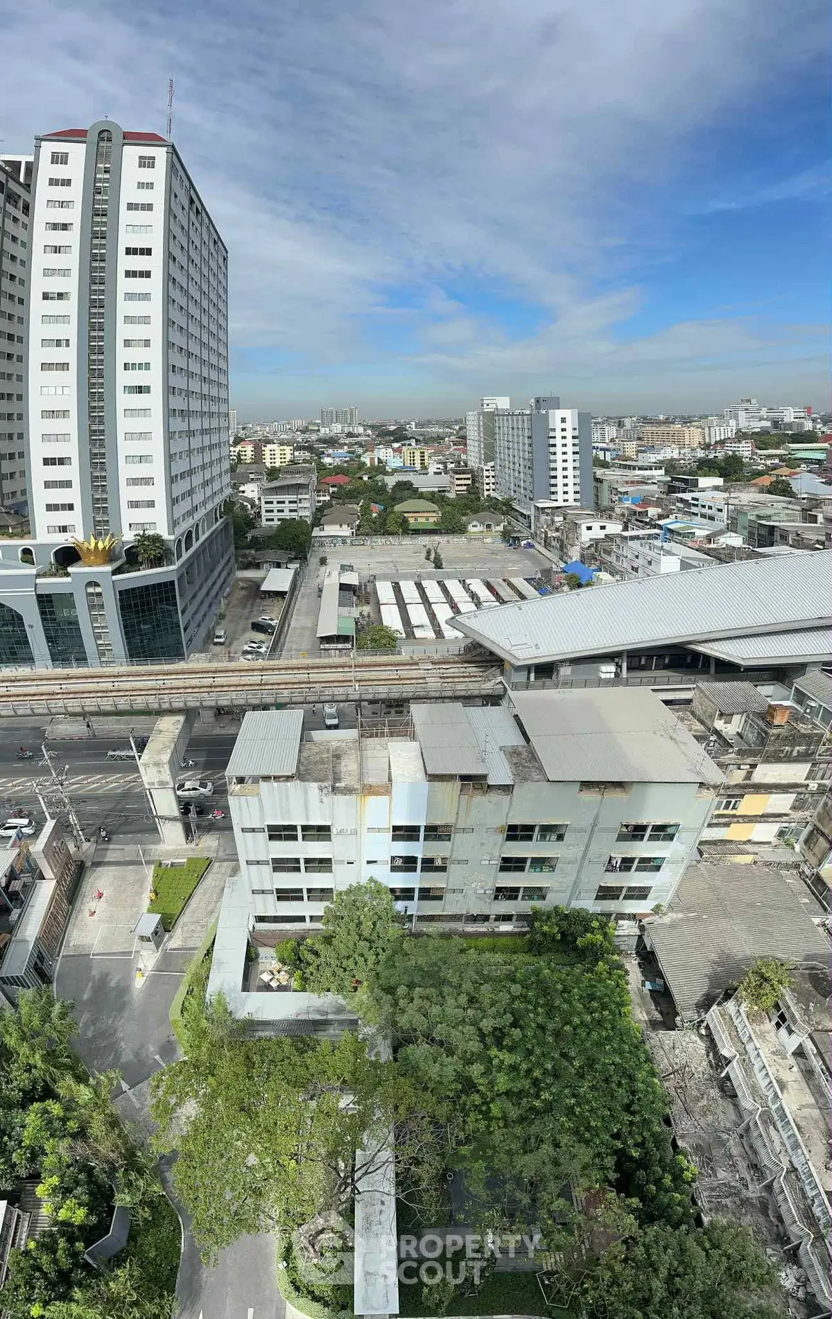 Panoramic cityscape view showcasing high-rise buildings and urban landscape under a clear blue sky.