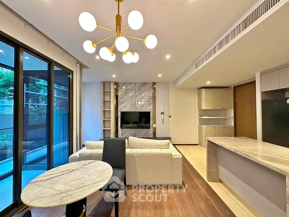 Modern living room with elegant lighting and open kitchen layout in luxury apartment.