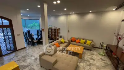 Spacious living room with modern furniture and dining area, featuring elegant marble flooring and ample natural light.
