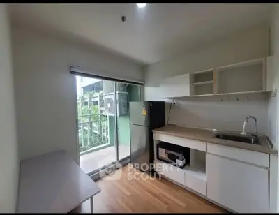 Modern kitchen with balcony access and sleek appliances in urban apartment