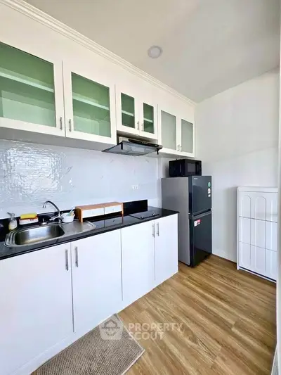 Modern kitchen with sleek cabinetry and stainless steel appliances in a bright apartment.
