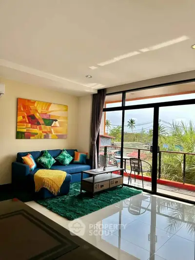 Spacious living room with vibrant decor and large windows opening to a scenic balcony view.