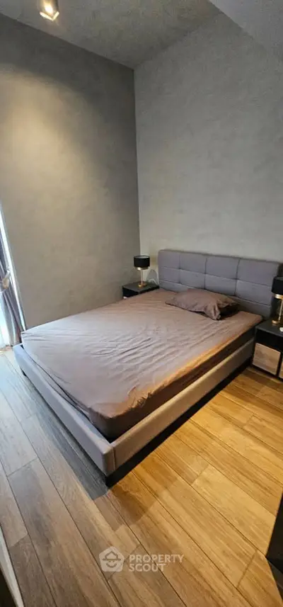 Modern bedroom with stylish bed and wooden flooring, perfect for a cozy retreat.
