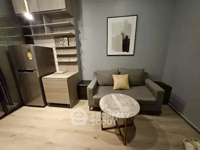 Modern living room with stylish sofa, marble coffee table, and sleek kitchen appliances.