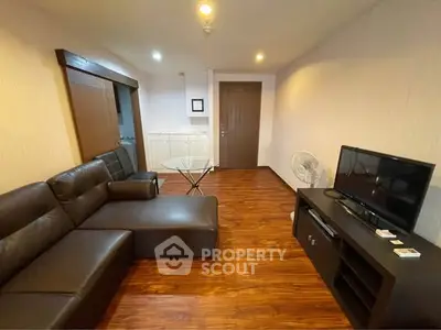 Spacious living room with modern leather sofa and wooden flooring