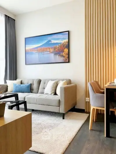 Modern living room with stylish decor and cozy seating area, featuring a scenic wall art and elegant furniture.