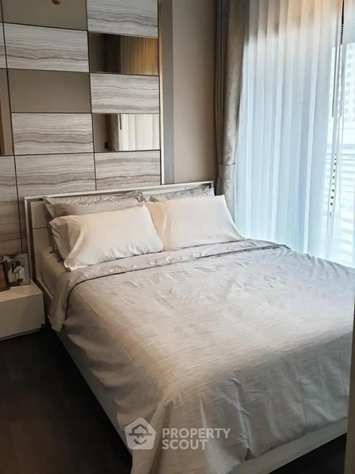 Modern bedroom with stylish decor and natural light, featuring a comfortable bed and elegant curtains.