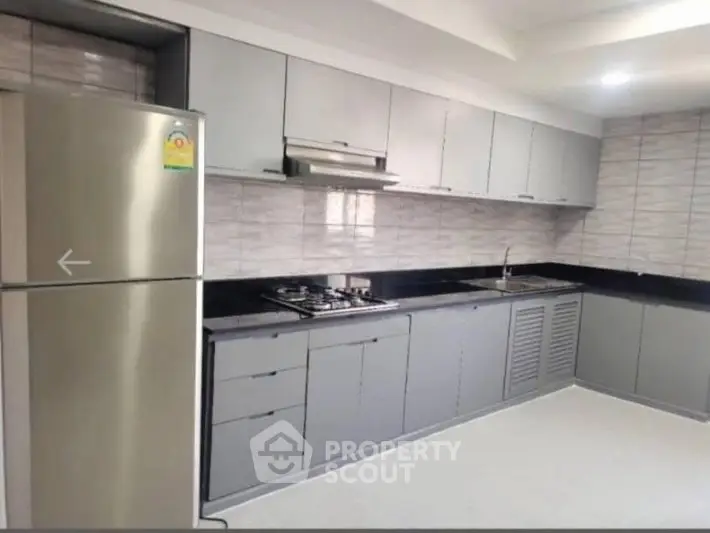 Modern kitchen with sleek cabinets and stainless steel appliances in a contemporary home.