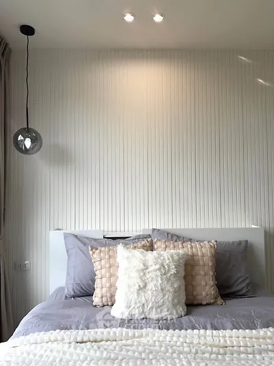 Cozy bedroom with modern decor and soft lighting, perfect for relaxation.