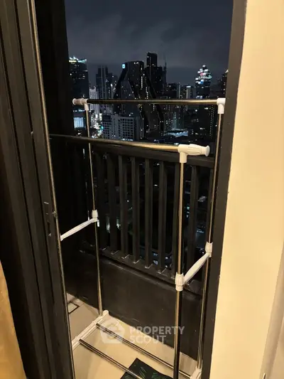 Chic urban balcony with stunning city skyline view at night, perfect for relaxation and enjoying the vibrant city life.