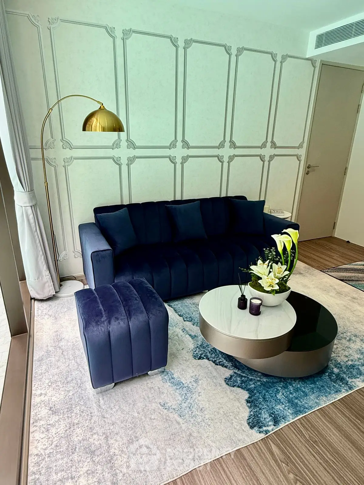 Elegant living room with modern blue sofa, stylish coffee table, and chic decor accents.