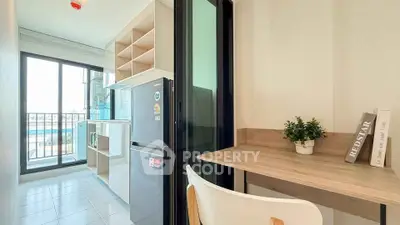 Modern kitchen with open layout and balcony view, featuring sleek appliances and stylish decor.