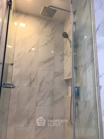 Luxurious marble-tiled bathroom with modern shower fixtures