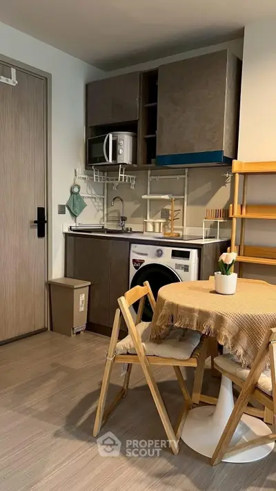 Charming compact kitchen with washing machine and dining area in modern apartment