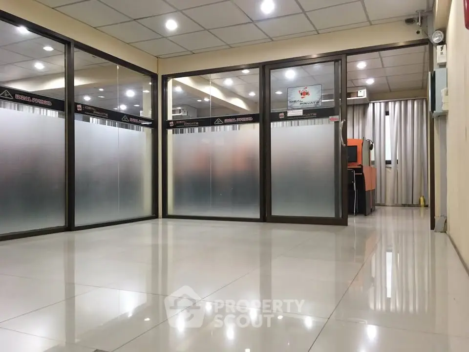 Spacious office interior with glass partitions and tiled flooring