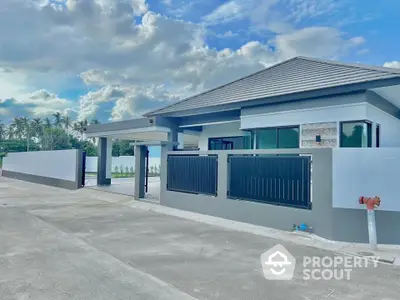 Modern single-story home with sleek design and spacious driveway under a vibrant sky.