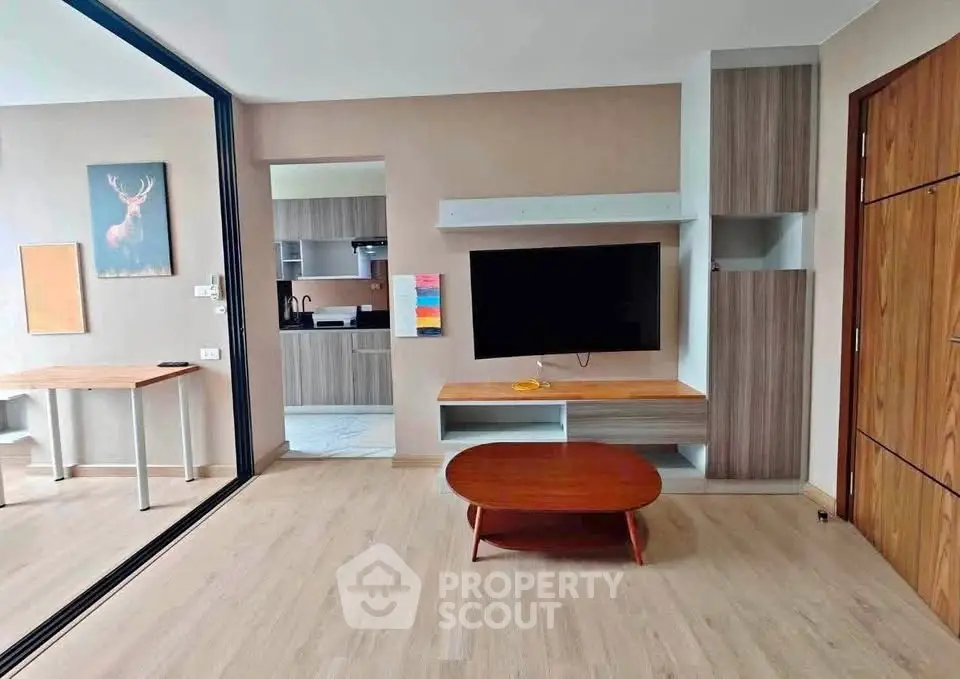 Modern living room with open layout and stylish kitchen in contemporary apartment.