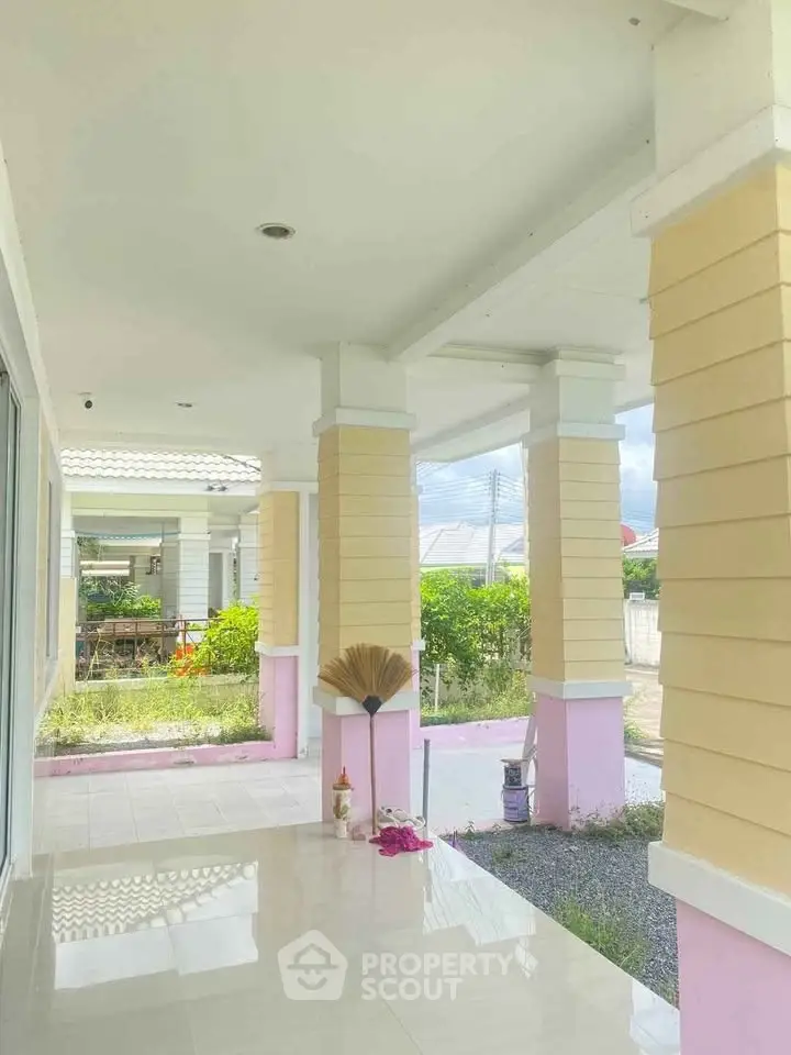 Charming exterior view of a modern home with elegant pillars and a spacious porch.