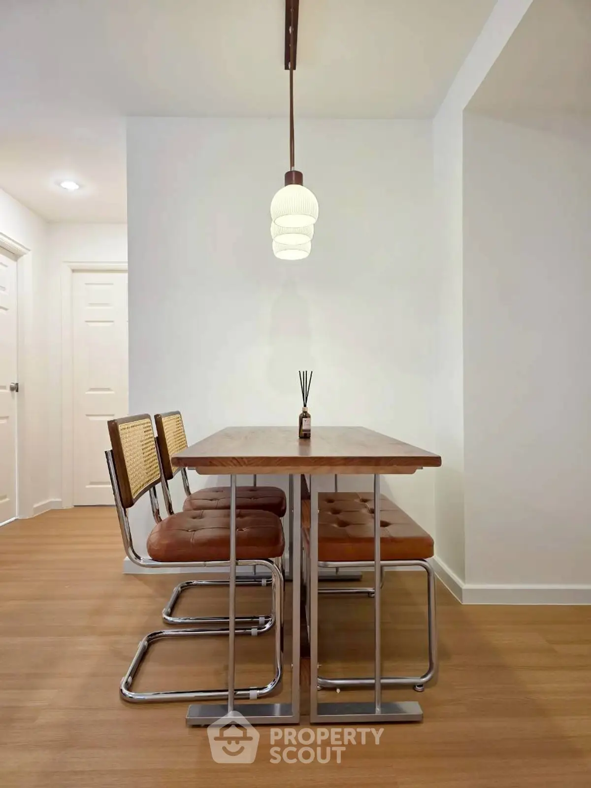 Modern dining area with stylish chairs and pendant light in a cozy home setting.
