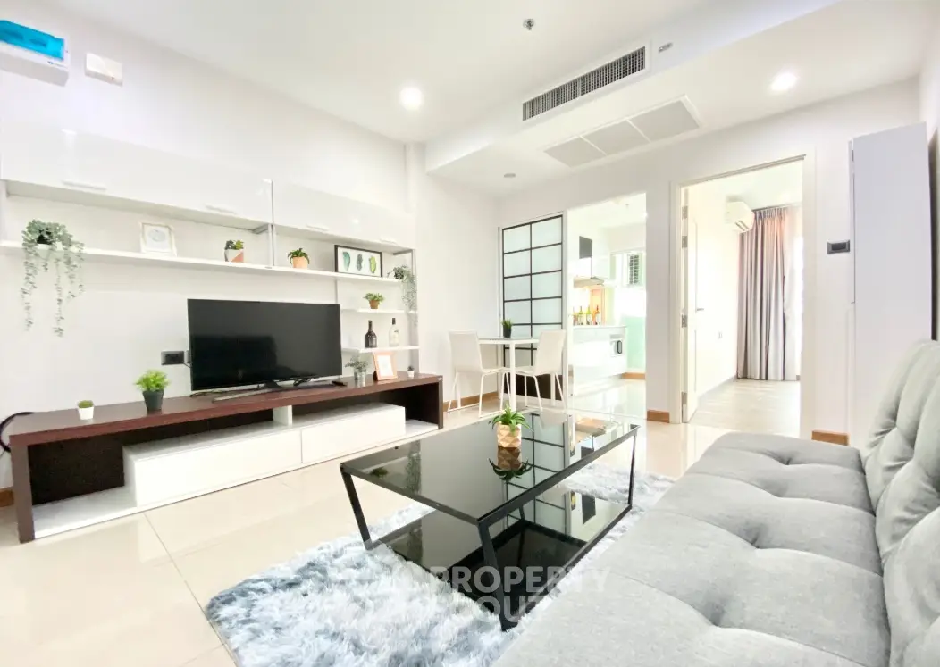 Modern living room with sleek furniture and open layout, featuring a cozy sofa and stylish decor.