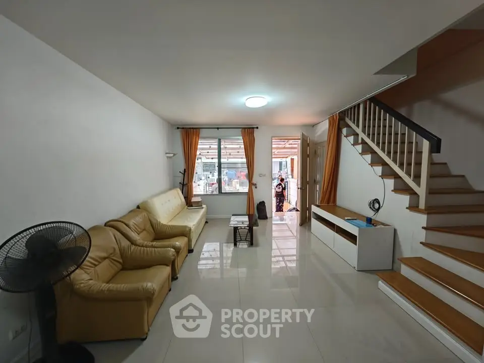 Spacious living room with modern staircase and cozy seating area