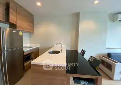 Modern kitchen with sleek design and integrated appliances in open layout apartment.