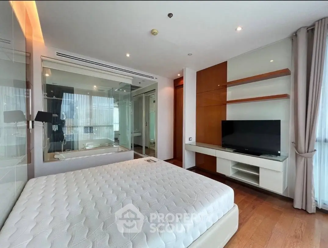 Luxurious bedroom with modern design and large windows offering natural light.
