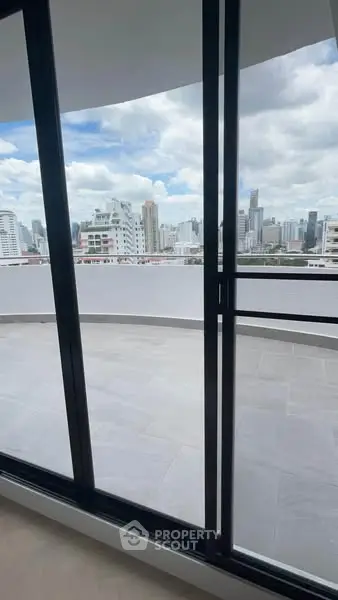 Stunning cityscape view from a spacious balcony in a modern high-rise apartment.