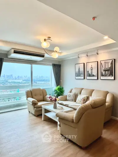 Spacious living room with city view, elegant decor, and cozy seating area.
