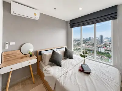Modern bedroom with city view, featuring stylish decor and natural light.