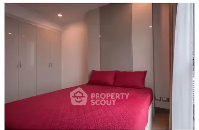 Cozy bedroom with modern built-in wardrobes and vibrant red bedding