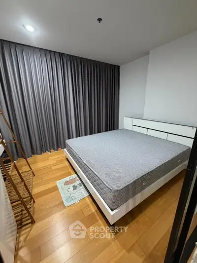 Modern bedroom with wooden flooring and stylish gray curtains