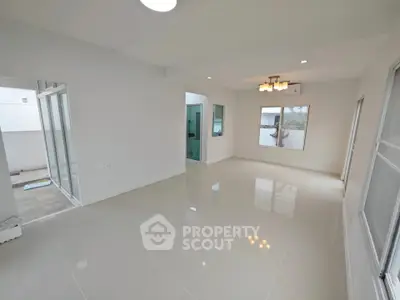 Spacious modern living room with large windows and elegant lighting