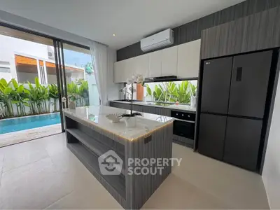 Modern kitchen with sleek design, island counter, and pool view, perfect for luxury living.