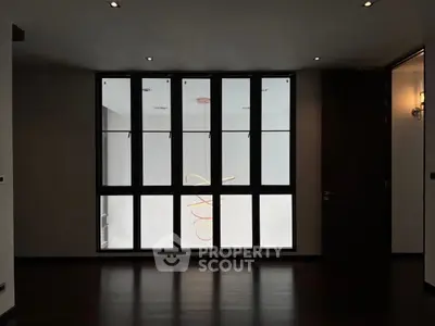 Spacious room with large windows and modern lighting fixture