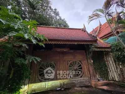 Charming traditional wooden house with ornate roof and lush greenery