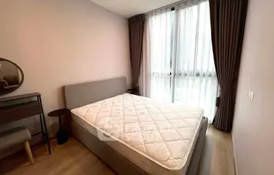 Modern bedroom with large window and stylish furniture in a cozy apartment.