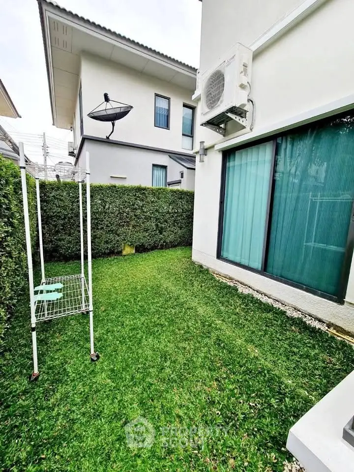 Charming backyard with lush green lawn and modern exterior, perfect for relaxation.