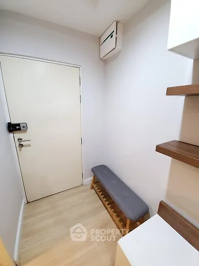 Modern entryway with sleek bench and wooden shelves, perfect for stylish urban living.
