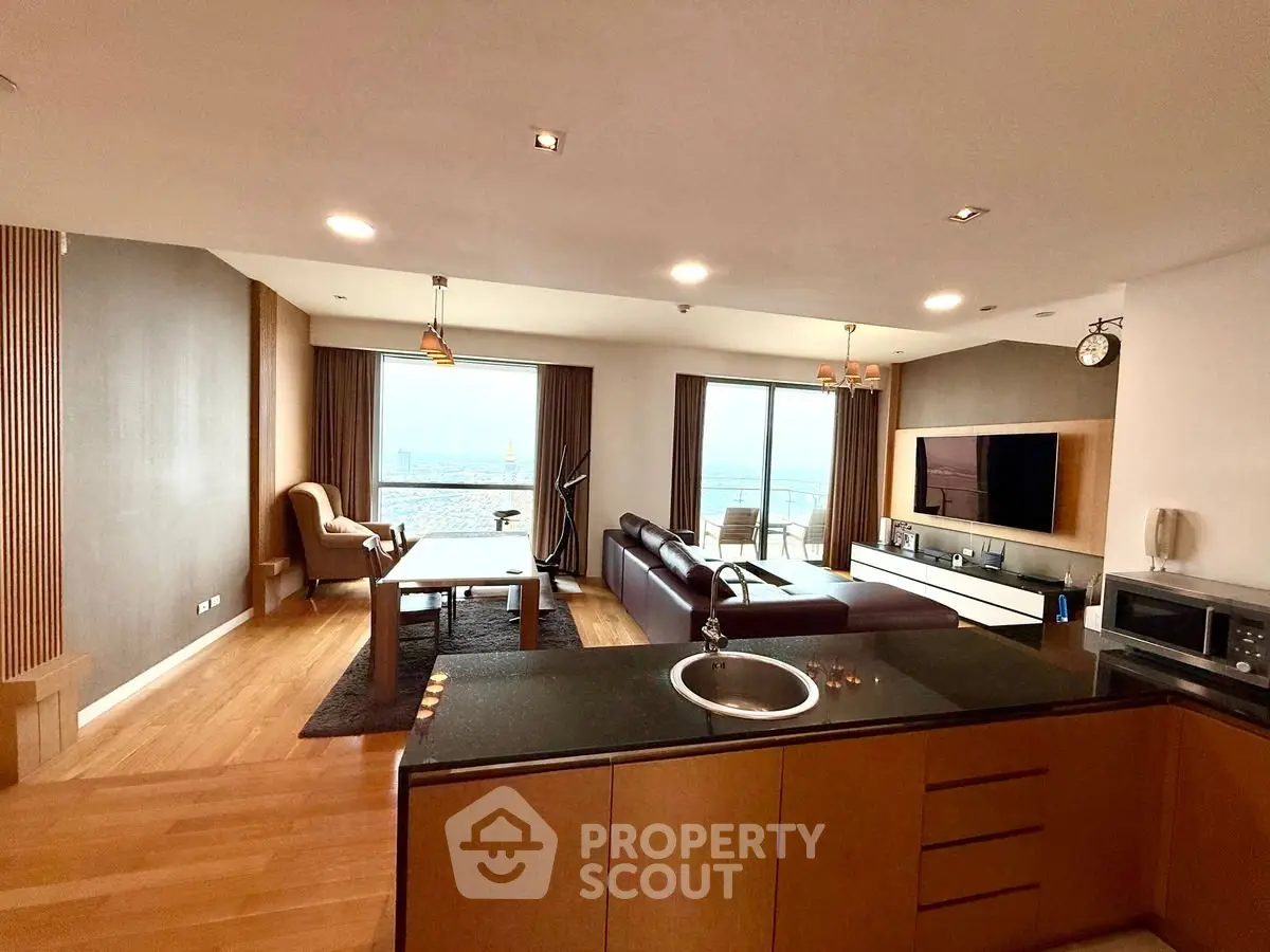 Spacious modern living room with open kitchen and stunning city view.