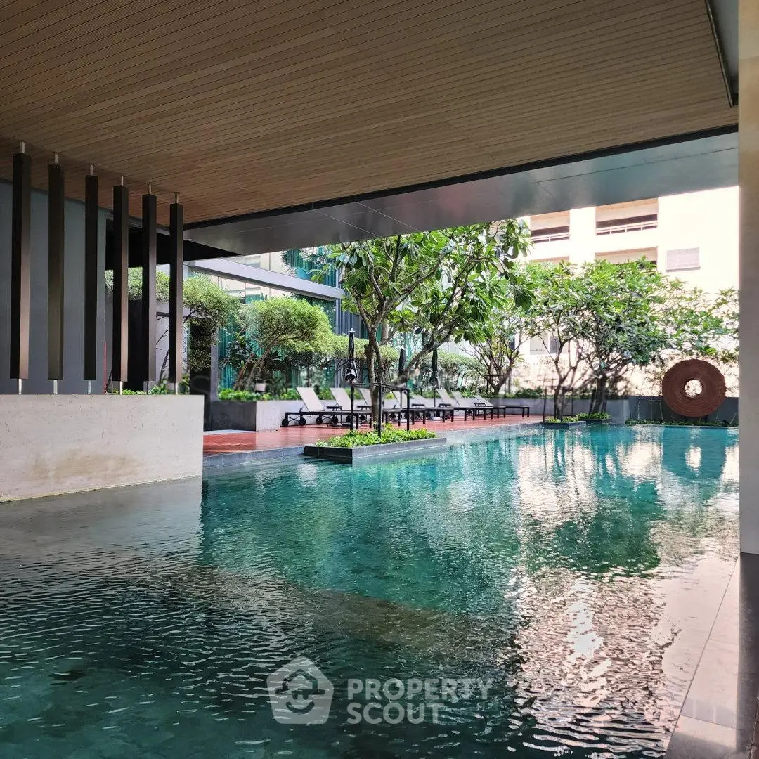 Luxurious residential pool area with lush greenery and modern design, perfect for relaxation and leisure.