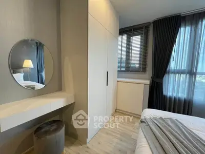 Modern bedroom with stylish decor, featuring a round mirror, sleek wardrobe, and large windows with curtains.