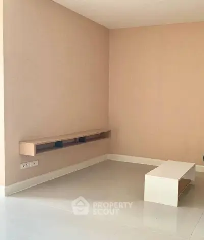 Minimalist living room with modern floating shelf and sleek coffee table.