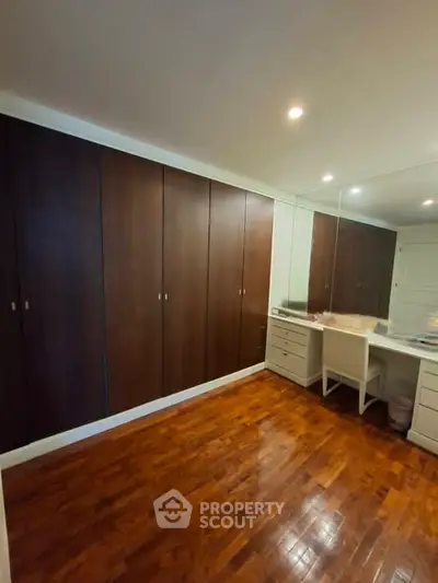 Spacious bedroom with wooden flooring and built-in wardrobe