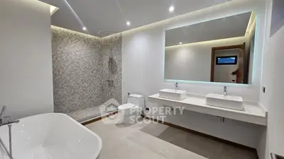 Luxurious modern bathroom with dual sinks, spacious shower, and elegant bathtub.